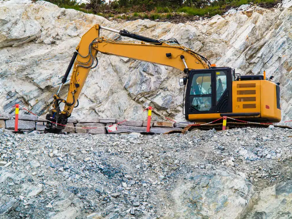 Industry. Heavy duty excavator machine, digger bulldozer working on stone construction site.
