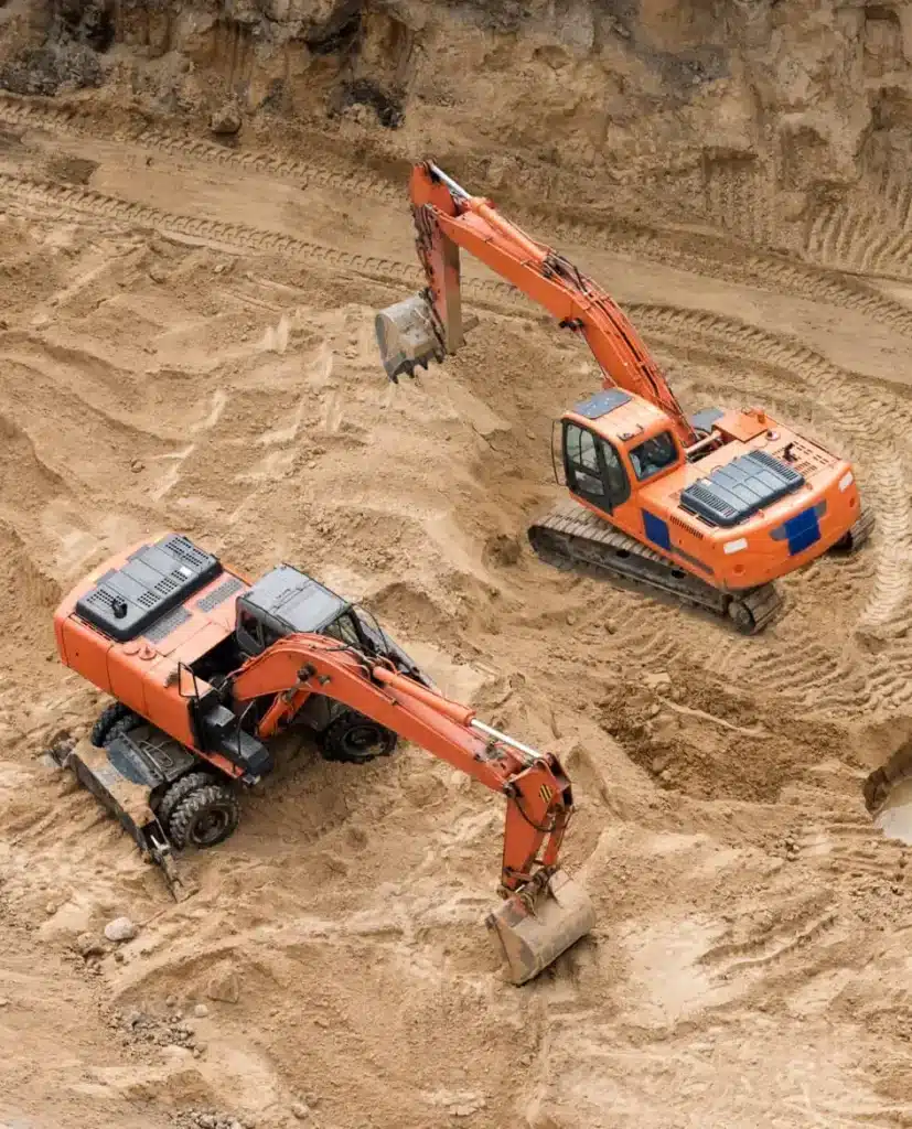 Excavators at sandpit during earthmoving works. Construction of concrete foundation of new building.