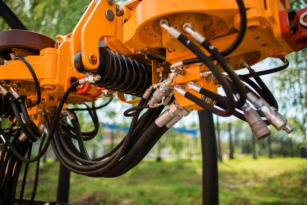 Close up of pipe system of hydraulic valves in agricultural machinery.