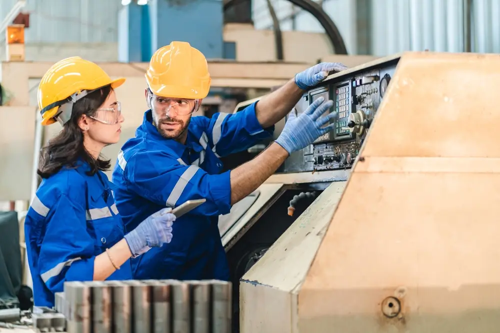 Artificial intelligence robotic technician concept, Factory engineer inspecting on machine with smart tablet. Worker works at heavy robot arm.
