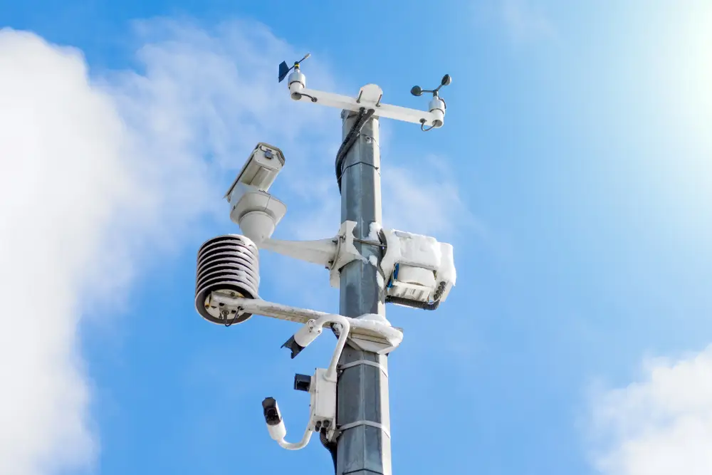 Automatic weather station, with a weather monitoring system and video cameras for observation. Against the background of a blue sky with clouds.